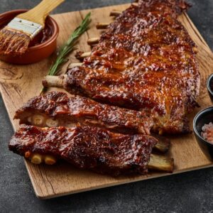 Slow-cooked BBQ ribs portion on a dark neutral background